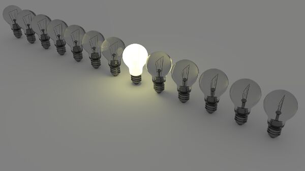 Row of lightbulbs with one lit